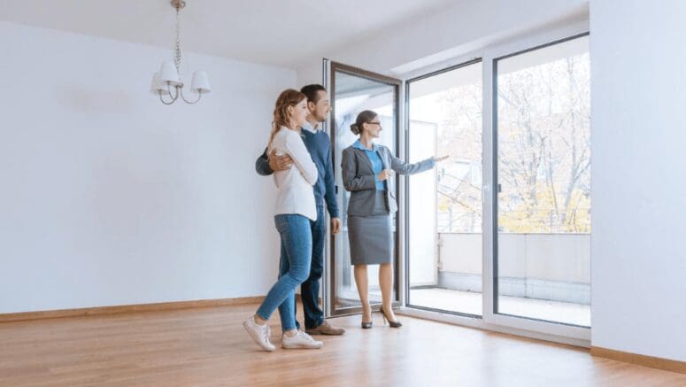 A real estate agent showing a couple a house to buy.